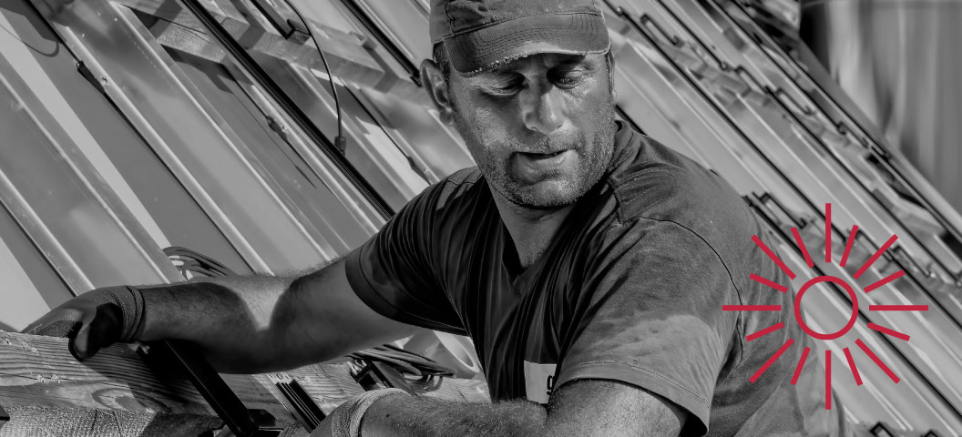 A man on a roof looking down.